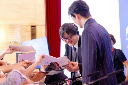 　サインに応じる細田守監督。右は岡田将生ⓒＫＡＺＵＫＯ　ＷＡＫＡＹＡＭＡ