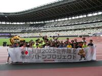 　小学生と写真に応じる（中央左奧の）高平慎士さん、（中央右奥の）織田裕二