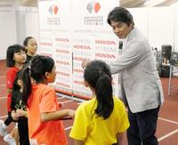 　小学生にリレーのバトンの渡し方を教える織田裕二（右）