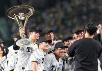 　トロフィーを手に記念写真に納まる佐藤輝（左）ら阪神ナイン（撮影・北村雅宏）