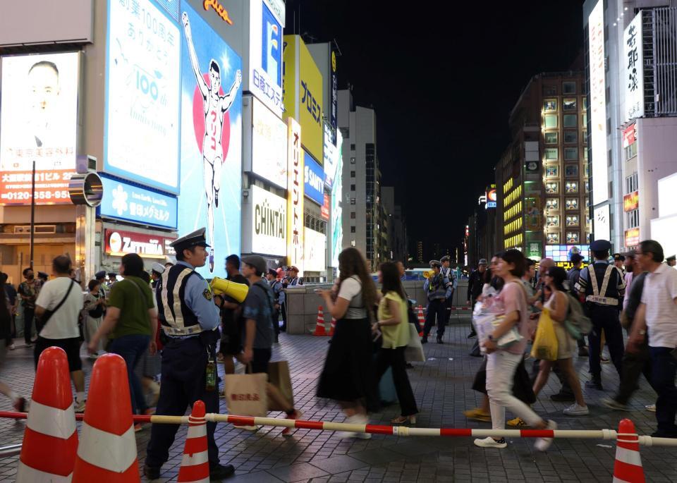 　警察官が警備する中、多くの人が行き交う戎橋