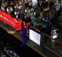 　道頓堀川に飛び込むミャクミャクの服を着た人　※写真の一部を加工しています