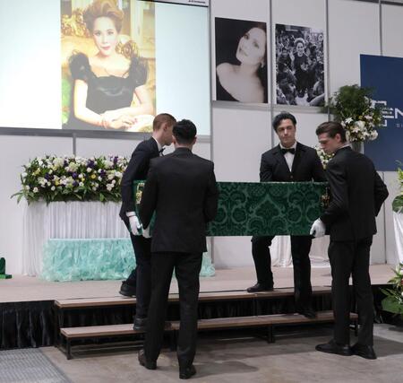 　イケメン４人に担がれた登場するデヴィ夫人の柩（撮影・西岡正）