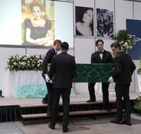 　イケメン４人に担がれた登場するデヴィ夫人の柩（撮影・西岡正）