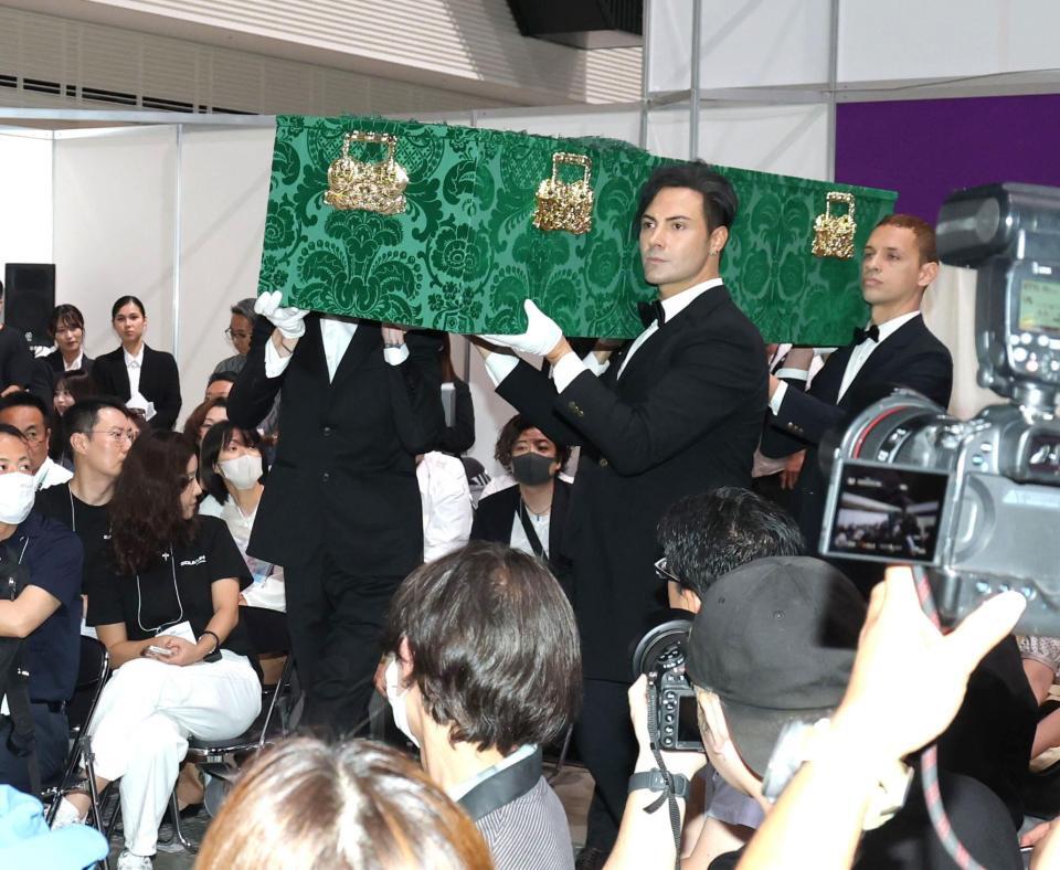 　イケメン４人に担がれて登場するデヴィ夫人の柩（撮影・西岡正）