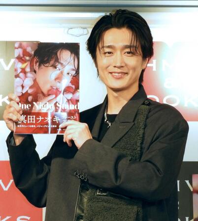 　写真集を手に笑顔の真田ナオキ