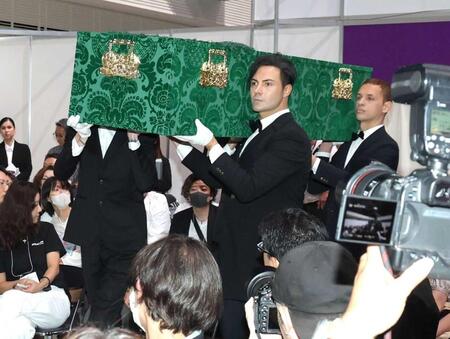 　イケメン４人に担がれて登場するデヴィ夫人のひつぎ（撮影・西岡正）