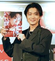 　写真集を手に笑顔の真田ナオキ