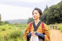 　那須の川沿いの道を歩くりん（見上愛）