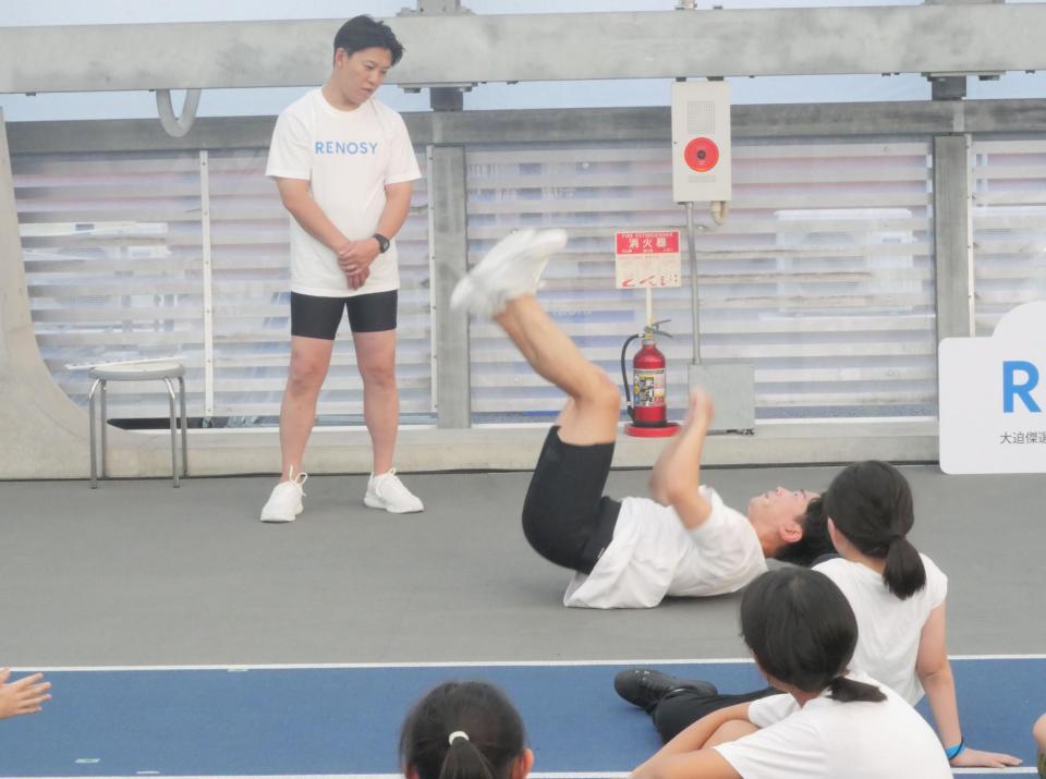 　イベントに参加した親子20組の前で得意の「背中ジャンプ」を披露するジャングルポケットの太田博久（右）と見守るおたけ