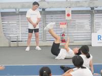 　イベントに参加した親子20組の前で得意の「背中ジャンプ」を披露するジャングルポケットの太田博久（右）と見守るおたけ