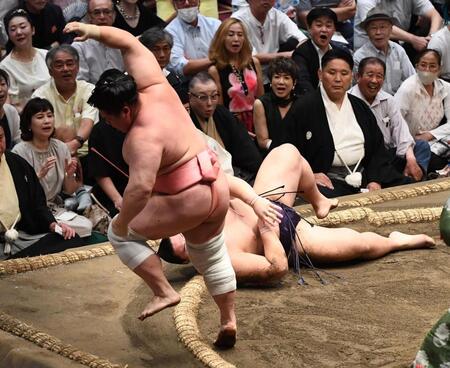 　草野（右）を引き落としで破った宇良。驚く和装の岩下尚史さん、右後方の黒いノースリーブの女性が黒田知永子＝１８日、両国国技館