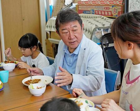 子どもたちと席を並べて食事をする自民党の茂木前幹事長＝21日
