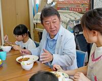 子どもたちと席を並べて食事をする自民党の茂木前幹事長＝21日