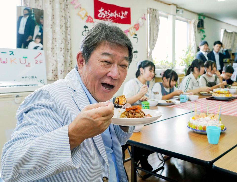 　子ども食堂を視察し、カレーライスを食べる自民党の茂木前幹事長＝21日