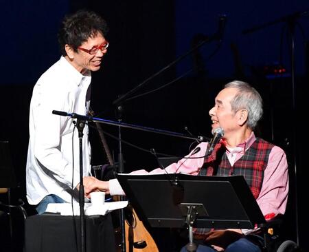 コンサートで南こうせつ（左）と握手する菅原孝さん＝２０１９年１１月
