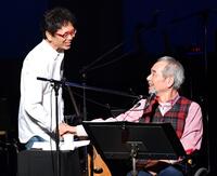 コンサートで南こうせつ（左）と握手する菅原孝さん＝２０１９年１１月