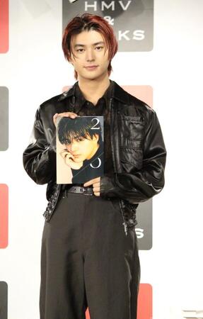 　写真集を持つ荒木飛羽