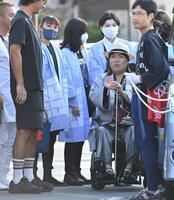 　車いすで「秦野たばこ祭」に登場したＬＵＮＡ　ＳＥＡ・真矢（右後方）に付き添う妻の石黒彩（左から３人目）＝撮影・開出牧