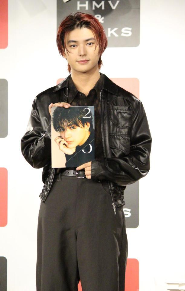 　写真集を持つ荒木飛羽