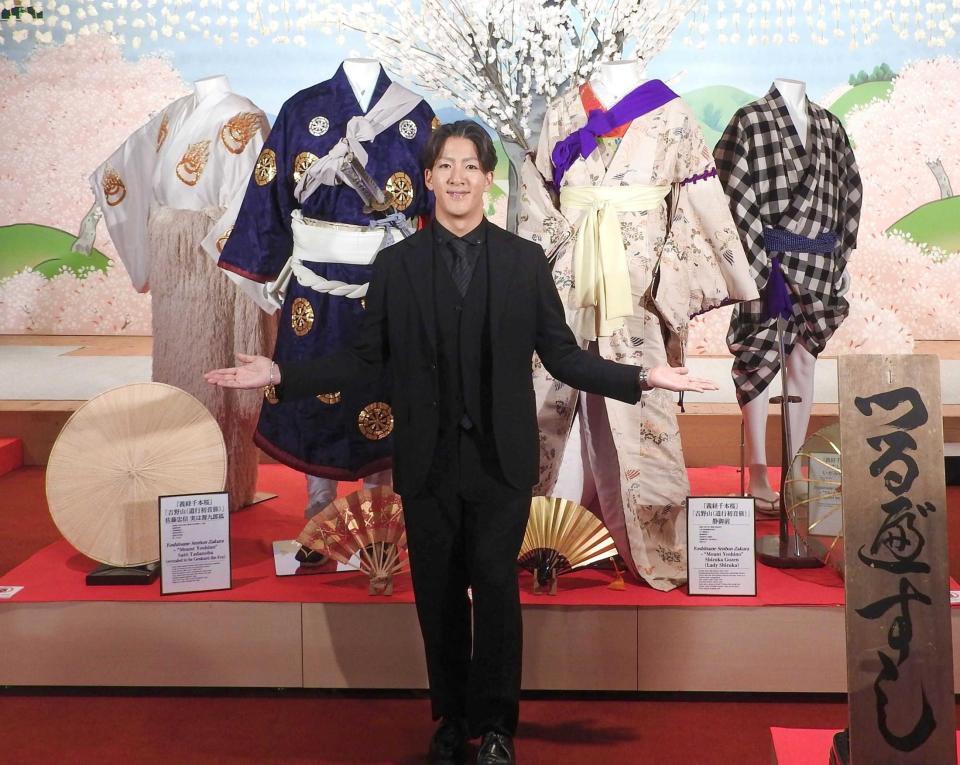　衣装の前でポーズをとる尾上右近