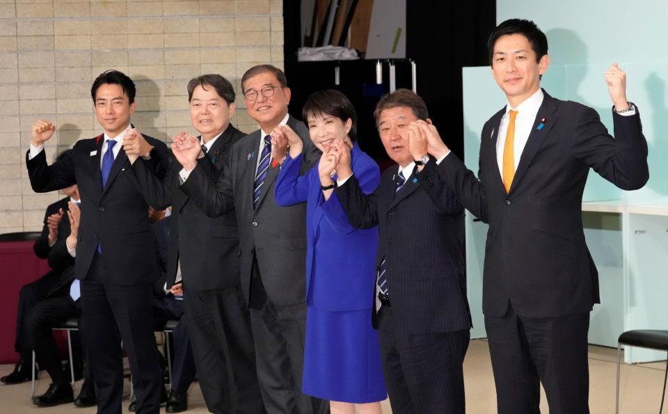 　自民党総裁選後に開かれた両院議員総会で、石破首相（中央左）や候補者と手を取り合う高市早苗新総裁（中央右）。女性初の総裁に選出された