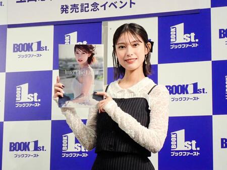 　写真集「Ｉｎｔｏ　Ｔｈｅ　Ｌｉｇｈｔ」を掲げる玉田志織