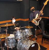 　スティックを手に笑顔を見せる。右は世良公則＝２０２１年９月