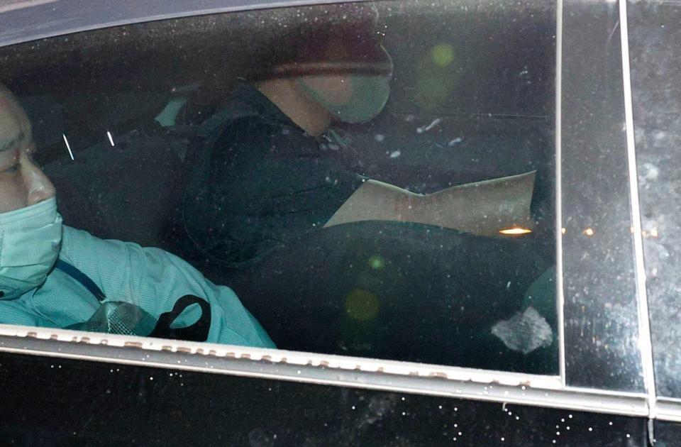 　かがんで警視庁四谷署を出る草間リチャード敬太容疑者（右下）