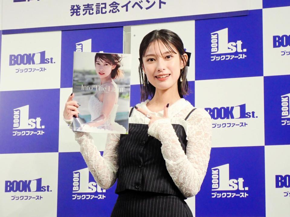 　写真集「Ｉｎｔｏ　Ｔｈｅ　Ｌｉｇｈｔ」を指す玉田志織