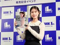 　写真集「Ｉｎｔｏ　Ｔｈｅ　Ｌｉｇｈｔ」を掲げる玉田志織