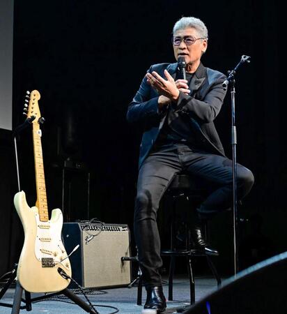 　ギターの横で話す吉川晃司