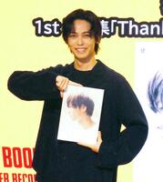 　写真集を手にする猪塚健太