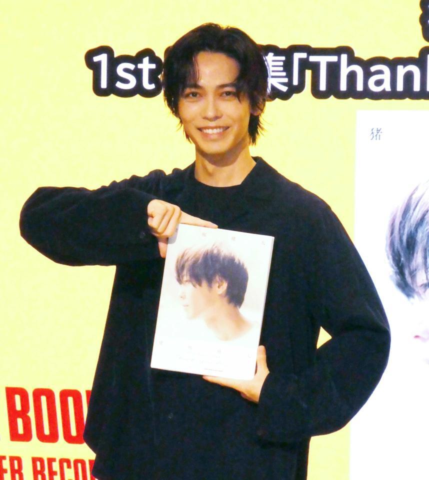 　写真集を手にする猪塚健太