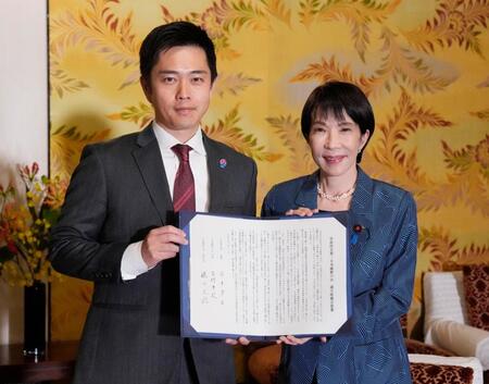 　署名した連立政権合意書を報道陣に示す自民党の高市総裁（右）と日本維新の会の吉村代表