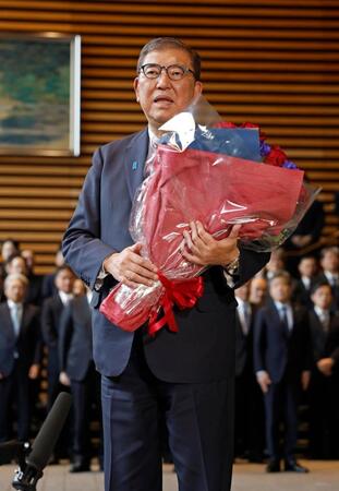 　花束を手に記者団の取材に応じる石破茂首相
