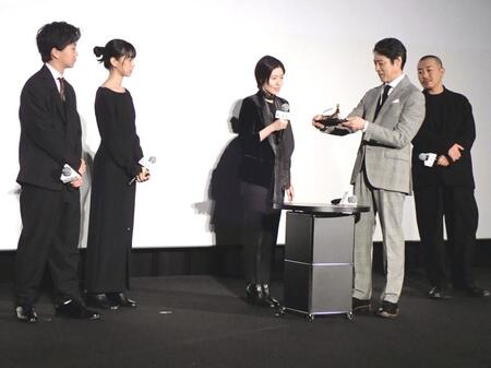 　ロカルノ国際映画祭金豹賞のトロフィーを手に取る堤真一（右から２人目）と（左から）高田万作、河合優実、シム・ウンギョン、１人置いて三宅唱監督