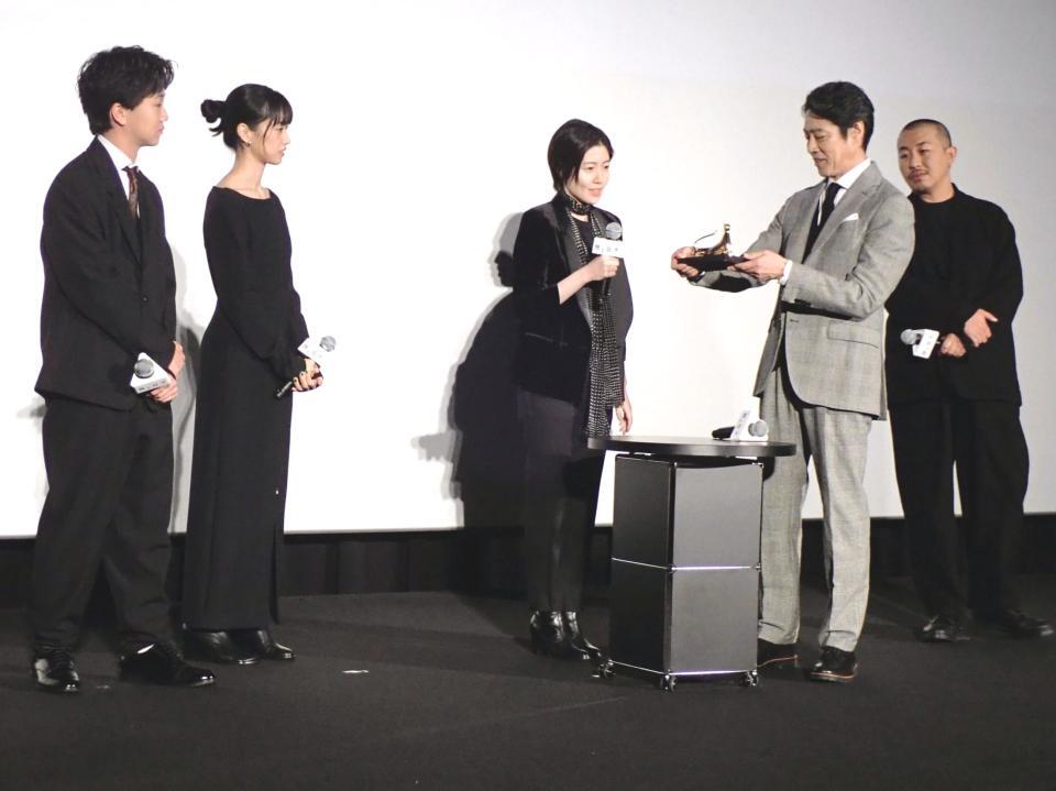 　ロカルノ国際映画祭金豹賞のトロフィーを手に取る堤真一（右から２人目）と（左から）高田万作、河合優実、シム・ウンギョン、１人置いて三宅唱監督
