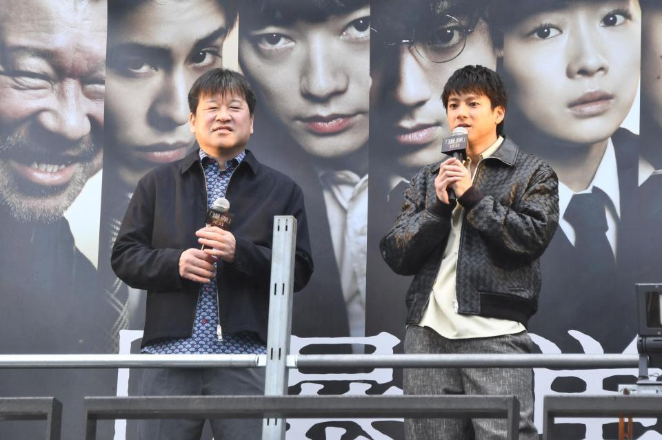 　演説する山田裕貴（右）と佐藤二朗　Ⓒ２０２５映画「爆弾」製作委員会