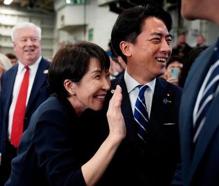 米海軍の原子力空母ジョージ・ワシントンの艦内で手を振る高市首相。右は小泉防衛相（ゲッティ＝共同）