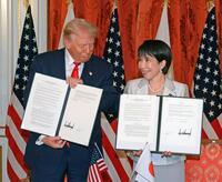 　会談後、署名した文書を手にする高市首相（右）とトランプ米大統領＝２８日（代表撮影）