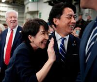 米海軍の原子力空母ジョージ・ワシントンの艦内で手を振る高市首相。右は小泉防衛相（ゲッティ＝共同）