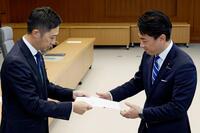 　秋田県の鈴木健太知事（左）から要望書を受け取る小泉防衛相＝２８日