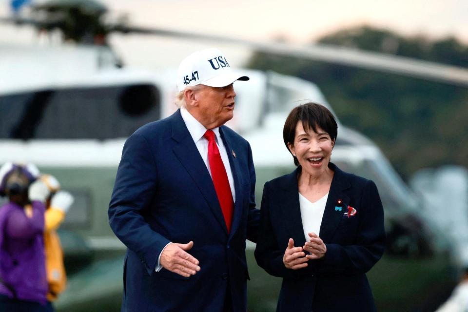 　米海軍の原子力空母ジョージ・ワシントンの艦上を歩く高市首相（右）とトランプ米大統領＝２８日（ロイター＝共同）