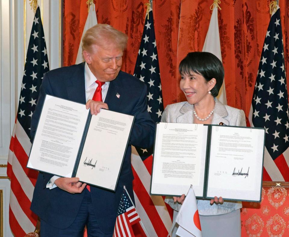 　会談後、署名した文書を手にする高市首相（右）とトランプ米大統領＝２８日（代表撮影）
