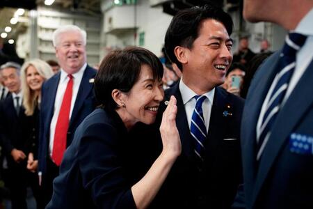 　米海軍の原子力空母ジョージ・ワシントンの艦内で手を振る高市首相。右は小泉防衛相＝２８日（ゲッティ＝共同）