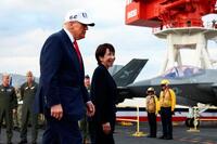 　米海軍の原子力空母ジョージ・ワシントンの艦上を歩く高市首相（右）とトランプ米大統領＝２８日（ロイター＝共同）