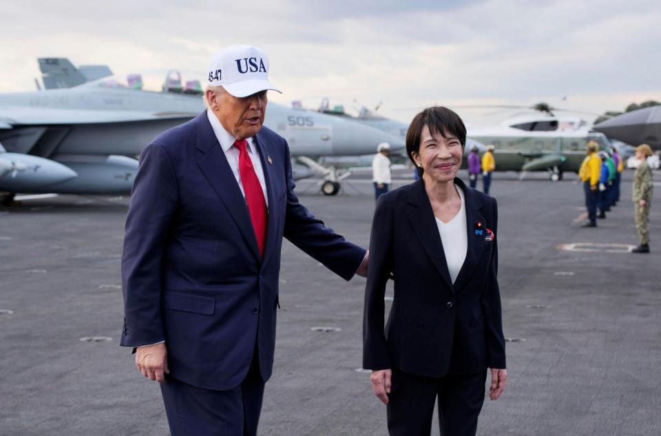 　米海軍の原子力空母ジョージ・ワシントンの艦上を歩く高市首相（右）とトランプ米大統領＝２８日（ゲッティ＝共同）