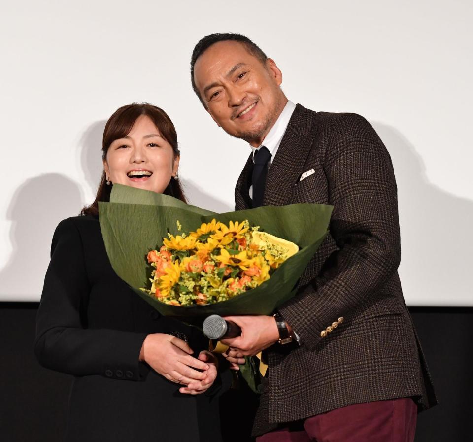 　初日舞台あいさつで原作者の柚月裕子氏（左）からひまわりの花束を受け取り笑顔の渡辺謙（撮影・開出牧）