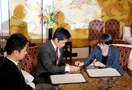 　１本の万年筆で連立政権合意書に署名する自民党の高市総裁（右）と日本維新の会の吉村代表（中央）＝１０月２０日